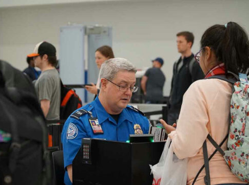 TSA agent checking a passengers documents at airport.