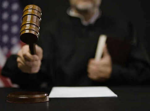 Judge hitting gavel in courtroom.