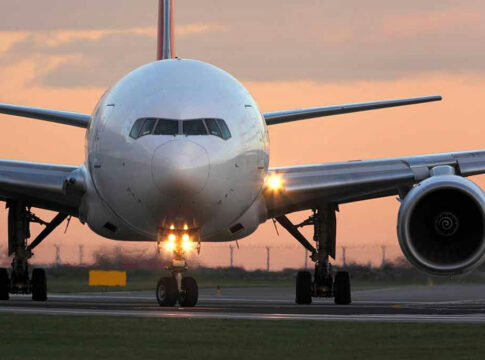 Airplane on runway during sunset.