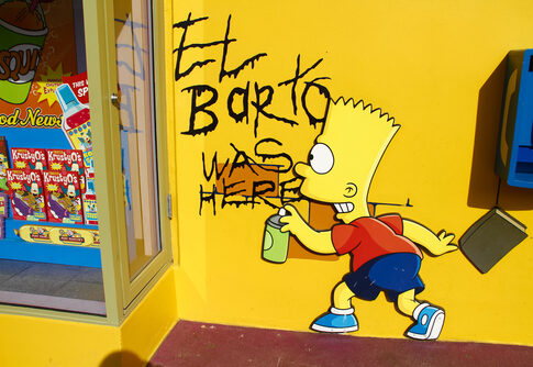 Graffiti of Bart Simpson writing El Barto was here on a yellow wall